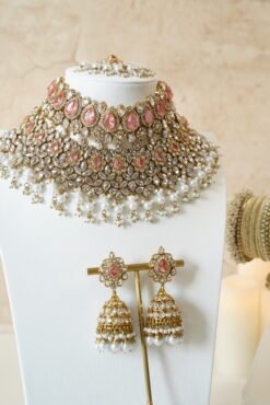 Seyora two-layer South Asian bridal necklace set featuring clear stone and pearl settings with a choker, longer necklace, matching jhumka earrings, and a maang tikka