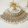 Two-layer Indian Pakistani bridal necklace set with clear stones and pearls featuring matching earrings and tikka, adjustable drawstring design for versatile styling