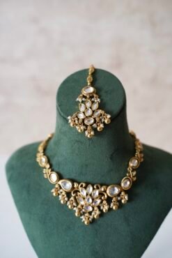 Small delicate floral kundan gold necklace set with jhumka earrings and matching tikka in traditional Indian design