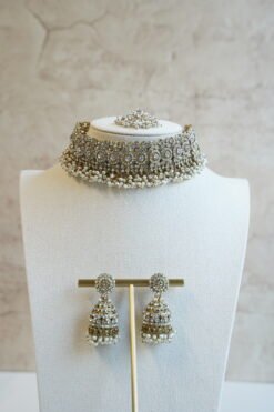 Three piece adjustable sparkling stone choker necklace set with matching earrings and a maang tikka with hanging pearl beads by Seyora Jewels.