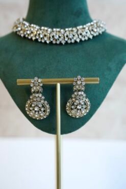 Delicate and sparkly small stone necklace set with matching drop earrings and pendant tikka reflecting light.