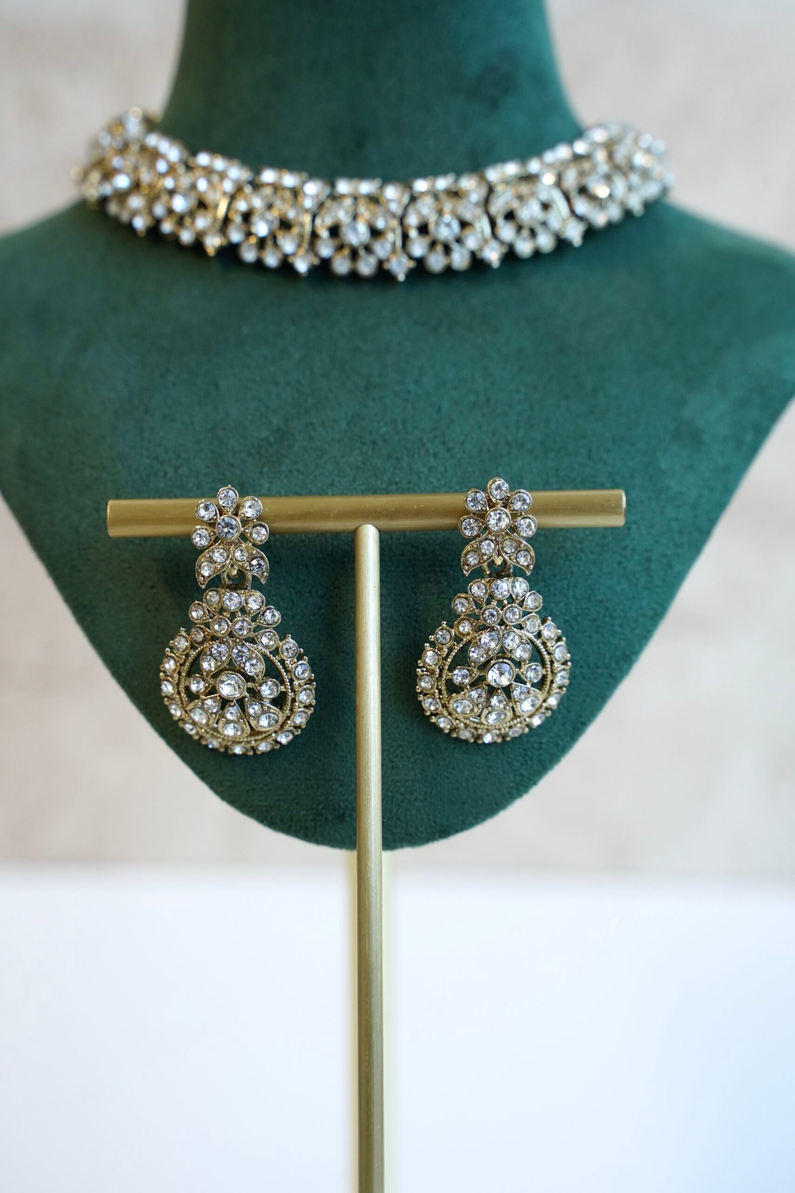 Delicate and sparkly small stone necklace set with matching drop earrings and pendant tikka reflecting light.