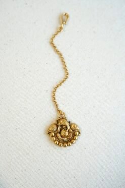 Traditional tikka featuring Lord Ganesha figure, designed for weddings, puja ceremonies, and festive cultural wear.