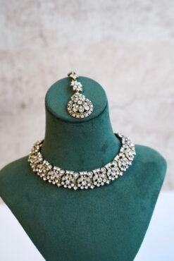 Delicate and sparkly small stone necklace set with matching drop earrings and pendant tikka reflecting light.
