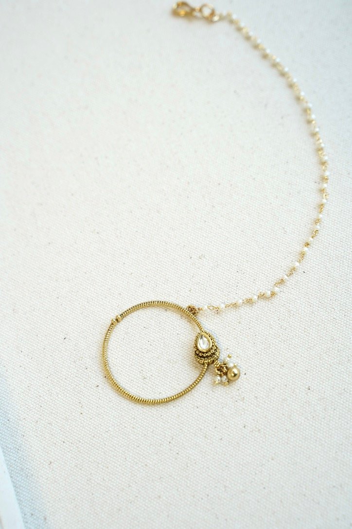 Oversized oval Kundan nath featuring a matte gold finish and a single-layer sleek chain by Seyora Jewels.