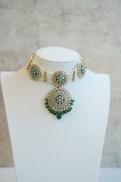 Green artificial Kundan choker necklace featuring a drop pendant and pearl beads, complete with matching earrings and tikka.