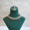 Delicate and sparkly small stone necklace set with matching drop earrings and pendant tikka reflecting light.