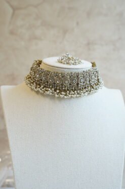 Three piece adjustable sparkling stone choker necklace set with matching earrings and a maang tikka with hanging pearl beads by Seyora Jewels.