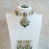 Green artificial Kundan choker necklace featuring a drop pendant and pearl beads, complete with matching earrings and tikka.