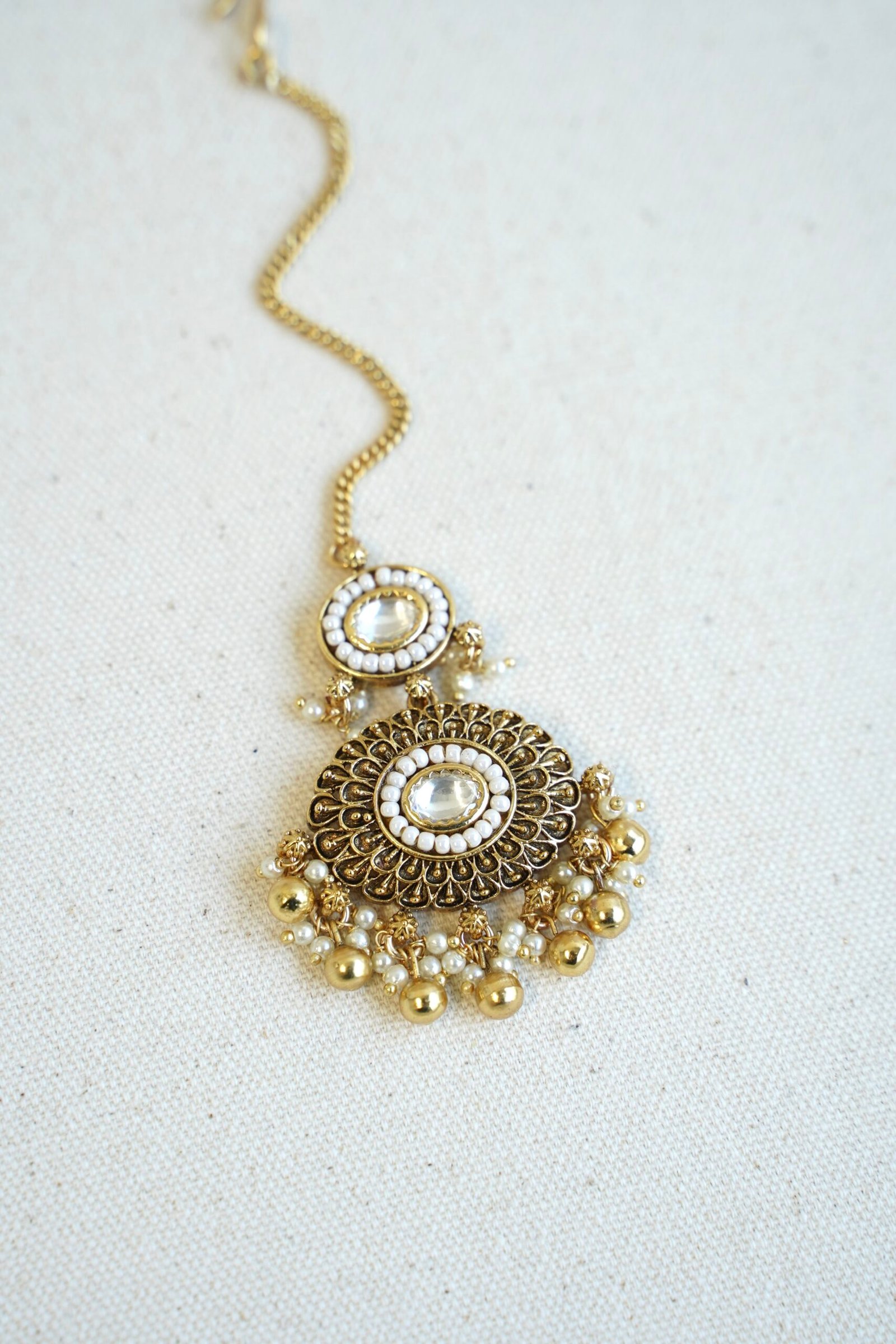 Traditional kundan tikka with elegant golden bead detailing for bridal, wedding, and festive wear.