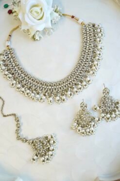 Sparkly flexible zircon necklace featuring flower shaped flower petal drop earrings and a matching pearl-beaded tikka.