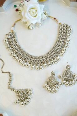 Sparkly flexible zircon necklace featuring flower shaped flower petal drop earrings and a matching pearl-beaded tikka.