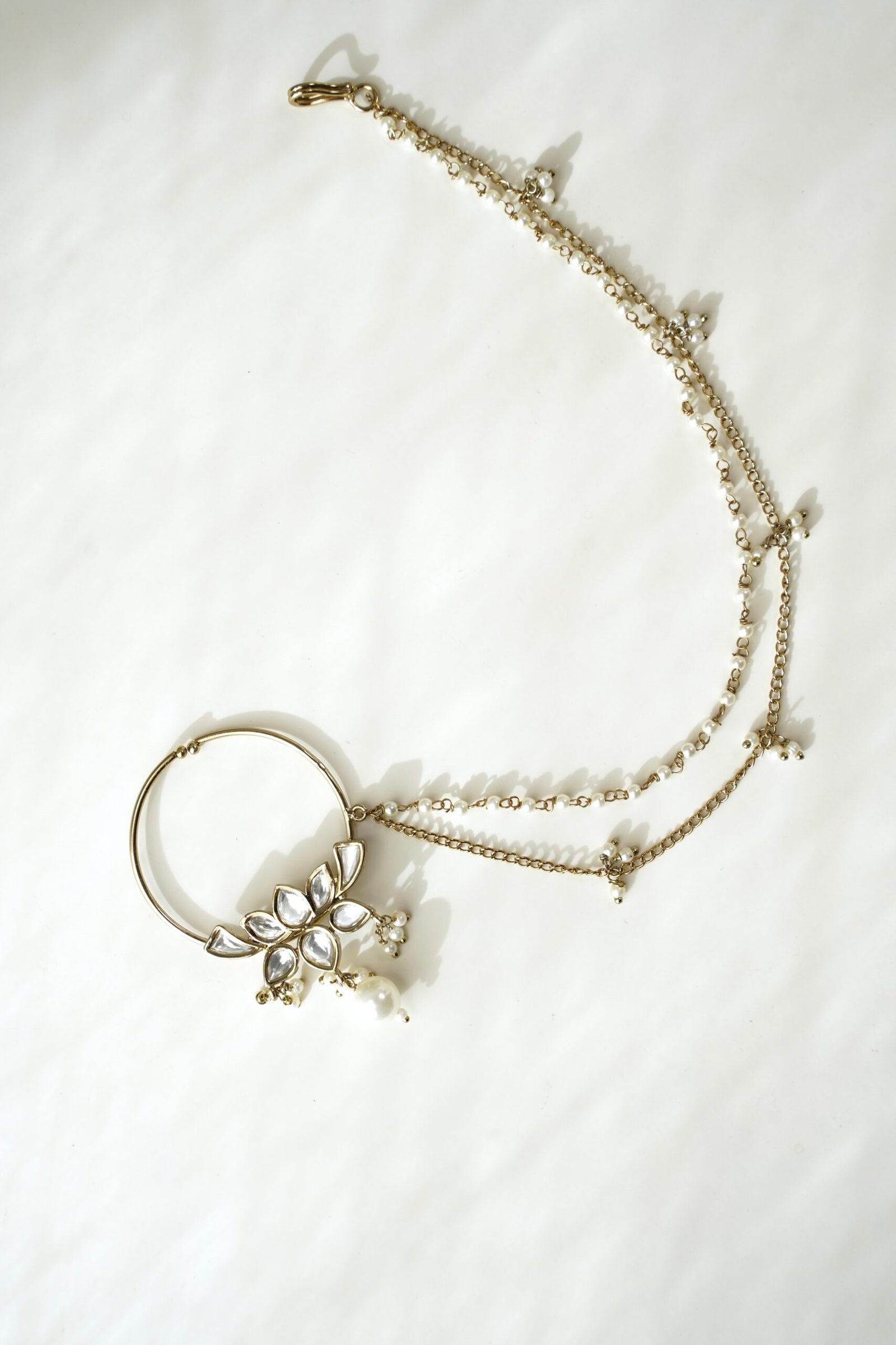 Mehndi polish Kundan nath featuring a lotus design, hanging pearl, and two-layer pearl chain by Seyora Jewels.