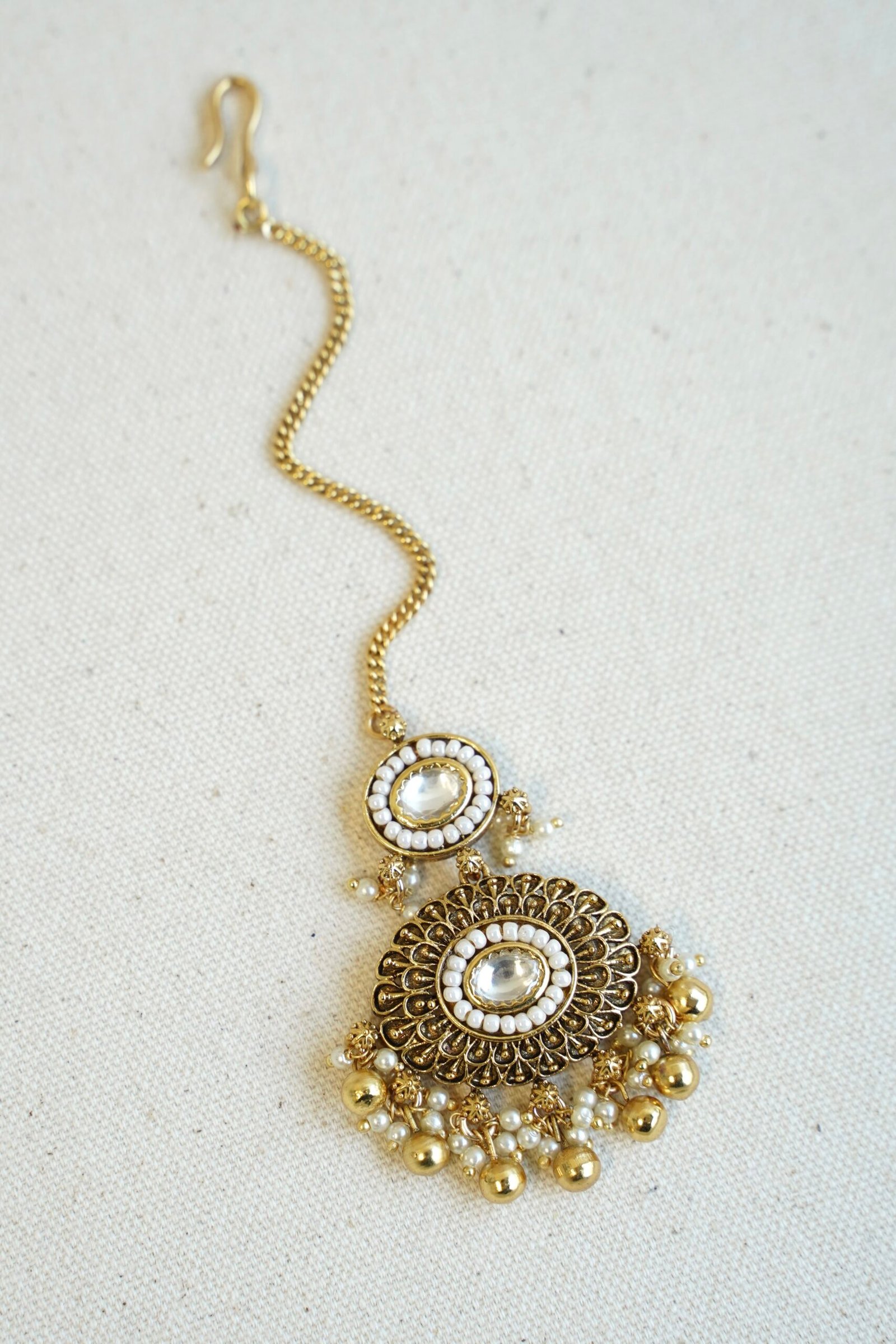 Traditional kundan tikka with elegant golden bead detailing for bridal, wedding, and festive wear.