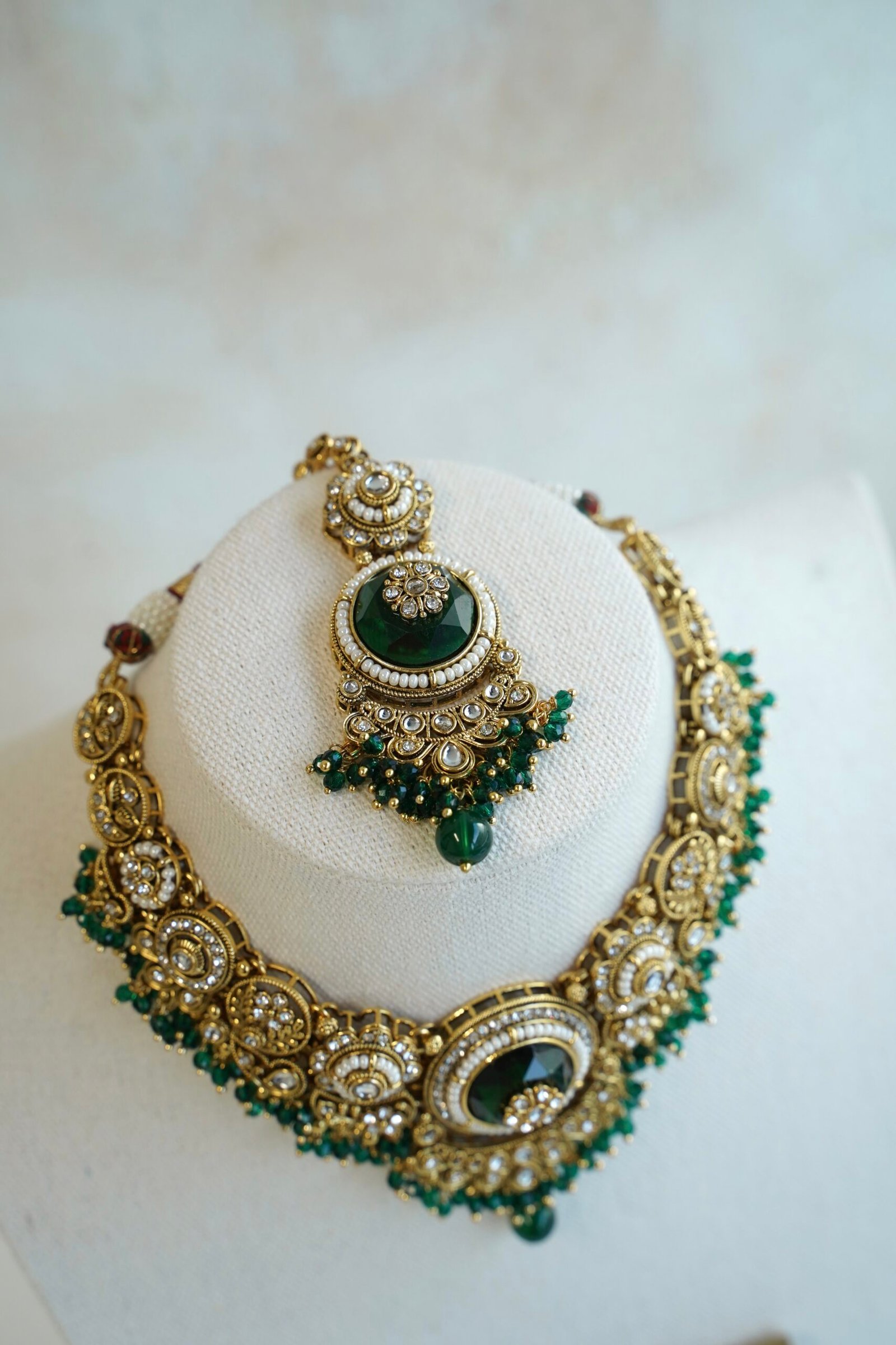 Lightweight green artificial Kundan necklace set with matching drop earrings and Maang Tikka for South Asian weddings.