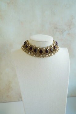 Seyora two-layer South Asian bridal necklace set featuring maroon stone and crystal bead settings with a choker, longer necklace, matching jhumka earrings, and a maang tikka