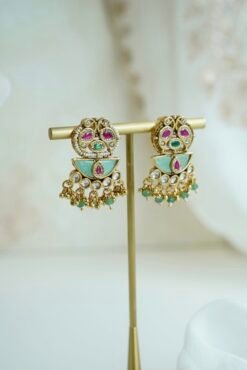 Intricate gold heritage Kundan choker necklace set featuring mint green enamel work, pink accents, and matching earrings on a display stand.