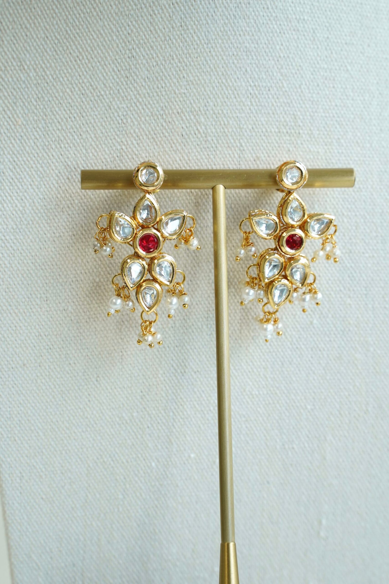 Seyora Jewels pearl choker set featuring detailed Kundan settings with red center stones on matching earrings and maang tikka.