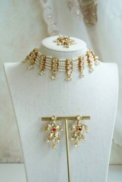 Seyora Jewels pearl choker set featuring detailed Kundan settings with red center stones on matching earrings and maang tikka.
