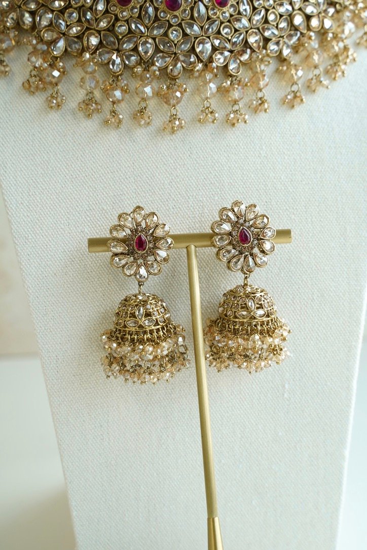 Seyora two-layer South Asian bridal necklace set featuring rani pink stone and pearl settings with a choker, longer necklace, matching jhumka earrings, and a maang tikka.