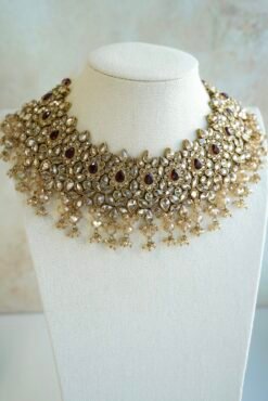 Seyora two-layer South Asian bridal necklace set featuring maroon stone and crystal bead settings with a choker, longer necklace, matching jhumka earrings, and a maang tikka