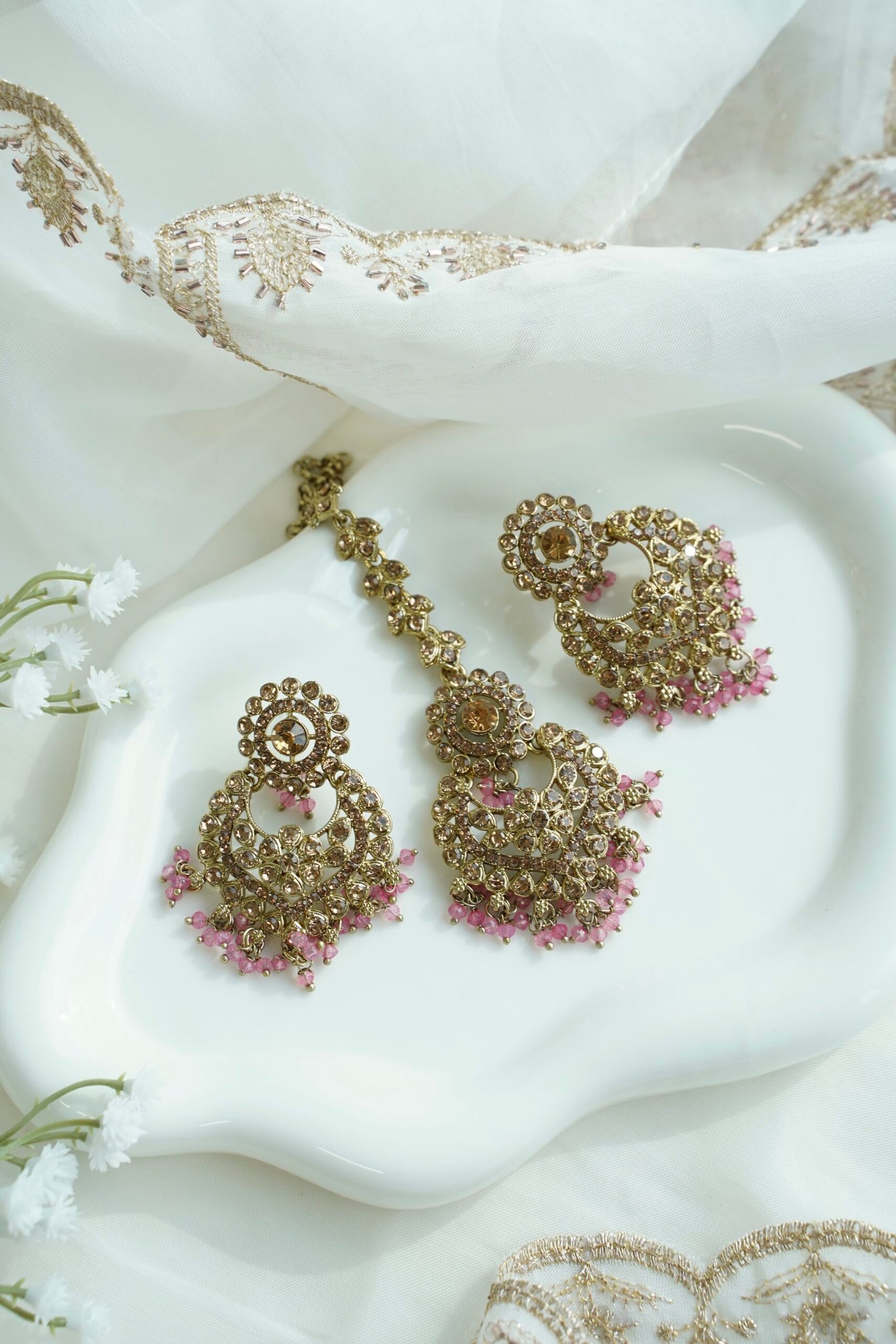 Seyora sparkling festive jewelry set featuring champagne stone earrings with hanging pink crystal beads and a matching maang tikka
