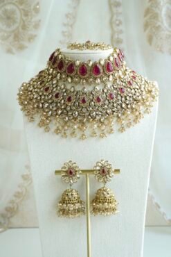 Seyora two-layer South Asian bridal necklace set featuring rani pink stone and pearl settings with a choker, longer necklace, matching jhumka earrings, and a maang tikka.