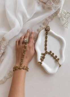 Seyora Jewels Diya floral Kundan hathpan hand chain featuring a kundan-studded flower ring and a detailed connecting chain linked to an adjustable wrist strap.