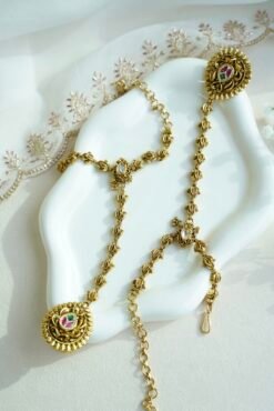 Seyora Jewels gold-plated Kundan hathpan hand chain featuring an oval rani pink and green finger ring connected to an adjustable wrist chain.