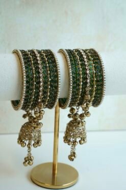 A stack of traditional South Asian glass bangles featuring a prominent central gold jhumka bangle adorned with hanging musical ghungroo beads by Seyora Jewels.