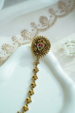 Seyora Jewels gold-plated Kundan hathpan hand chain featuring an oval rani pink and green finger ring connected to an adjustable wrist chain.