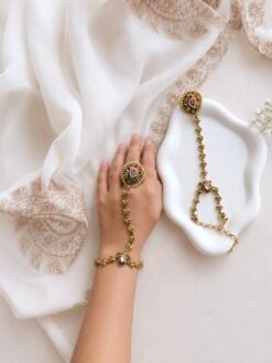 Seyora Jewels Kiran gold-plated Kundan hathpan hand chain featuring an oval rani pink and green finger ring connected to an adjustable wrist chain.