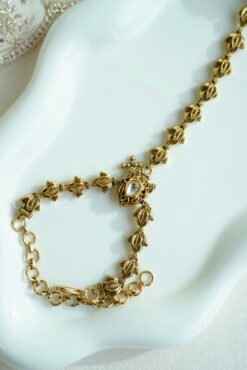 Seyora Jewels gold-plated Kundan hathpan hand chain featuring an oval rani pink and green finger ring connected to an adjustable wrist chain.