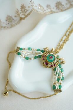 Seyora Jewels Mira heritage hathpan hand chain featuring an adjustable rani pink stone ring and green bead wrist detailing.