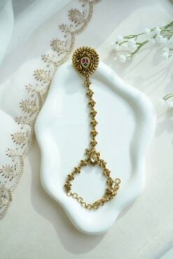 Seyora Jewels gold-plated Kundan hathpan hand chain featuring an oval rani pink and green finger ring connected to an adjustable wrist chain.