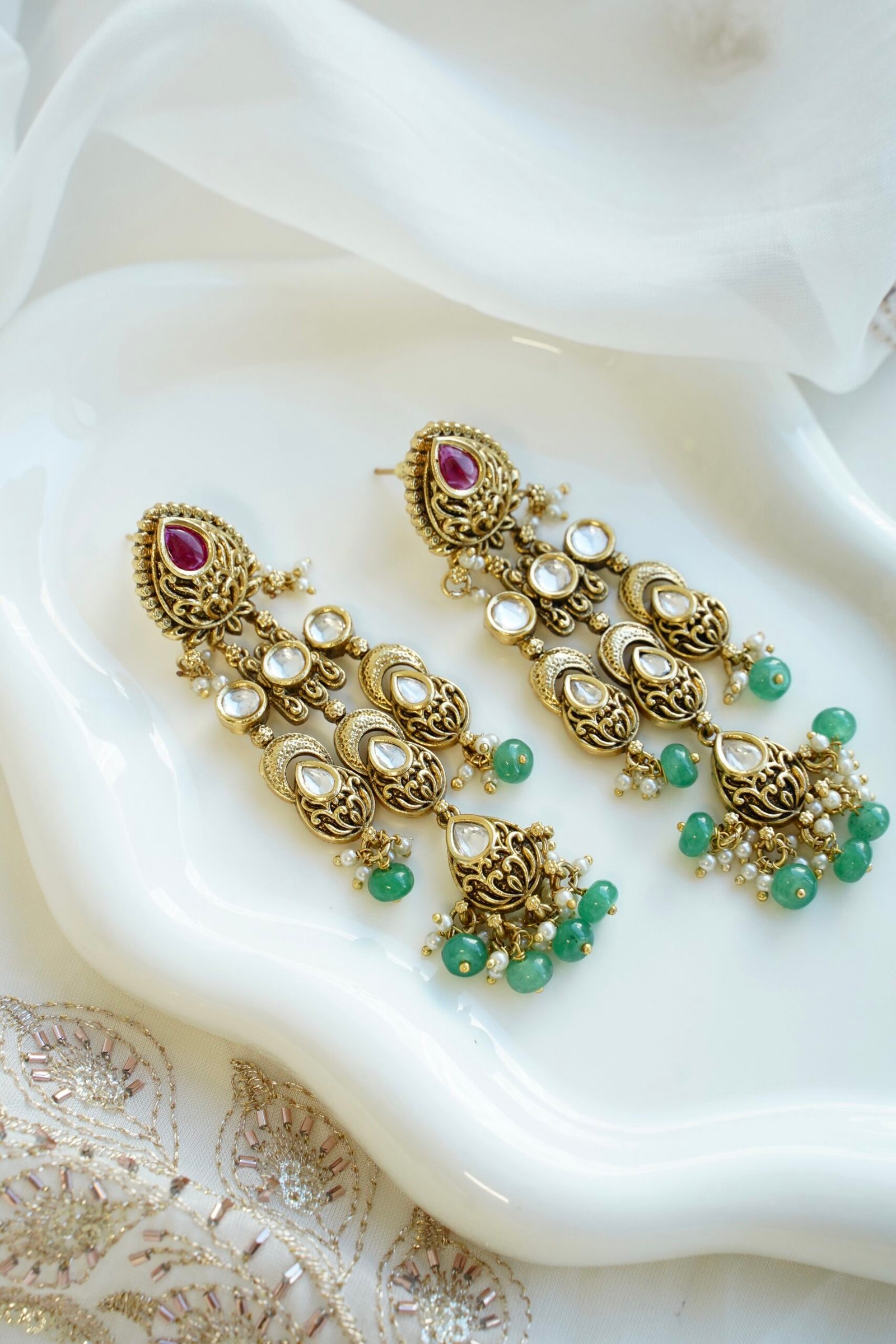 Slim kundan chandelier earrings in pink and green with pearl accents, South Asian festive jewelry