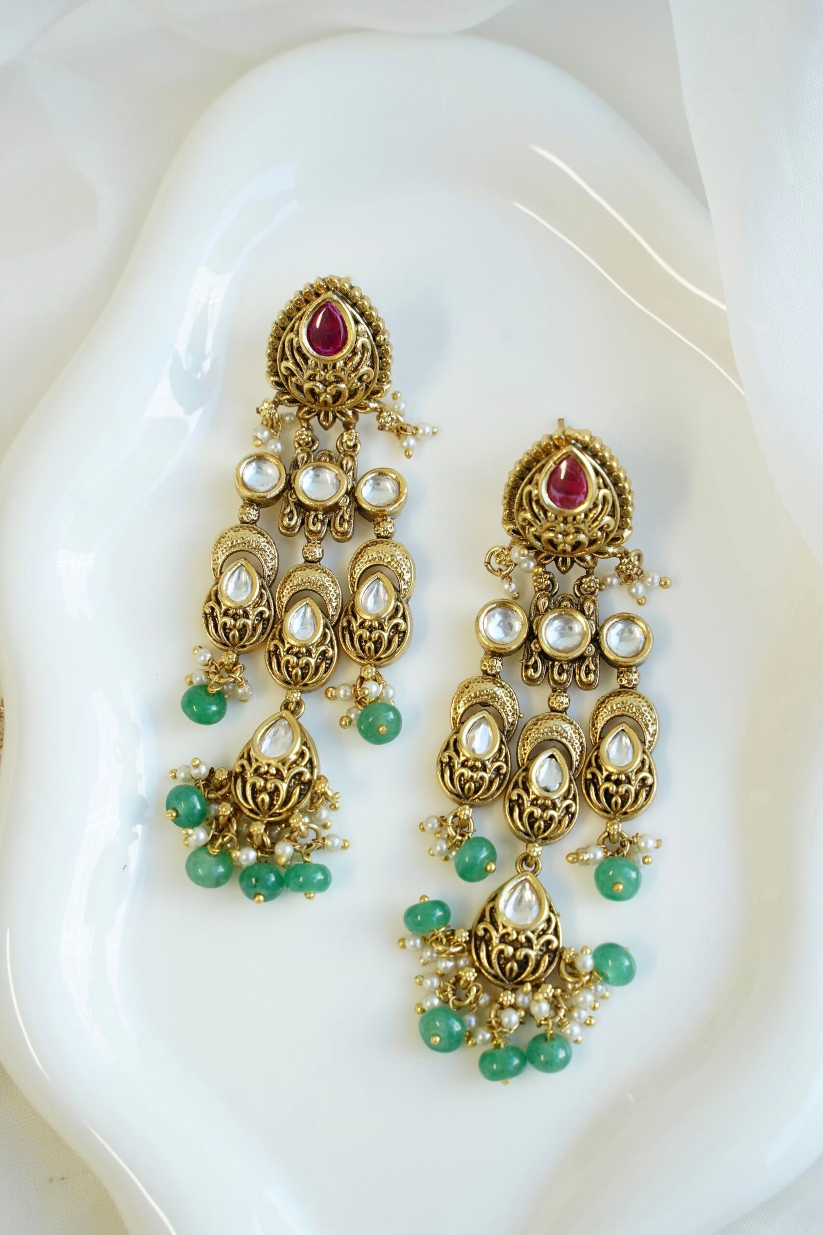 Slim kundan chandelier earrings in pink and green with pearl accents, South Asian festive jewelry