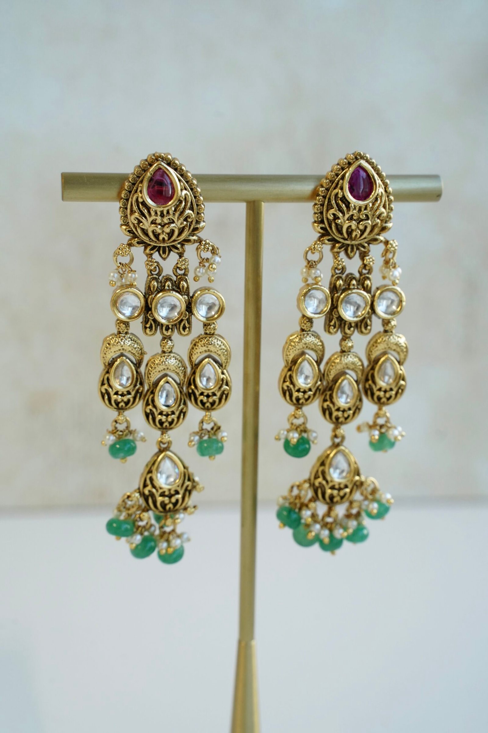 Slim kundan chandelier earrings in pink and green with pearl accents, South Asian festive jewelry