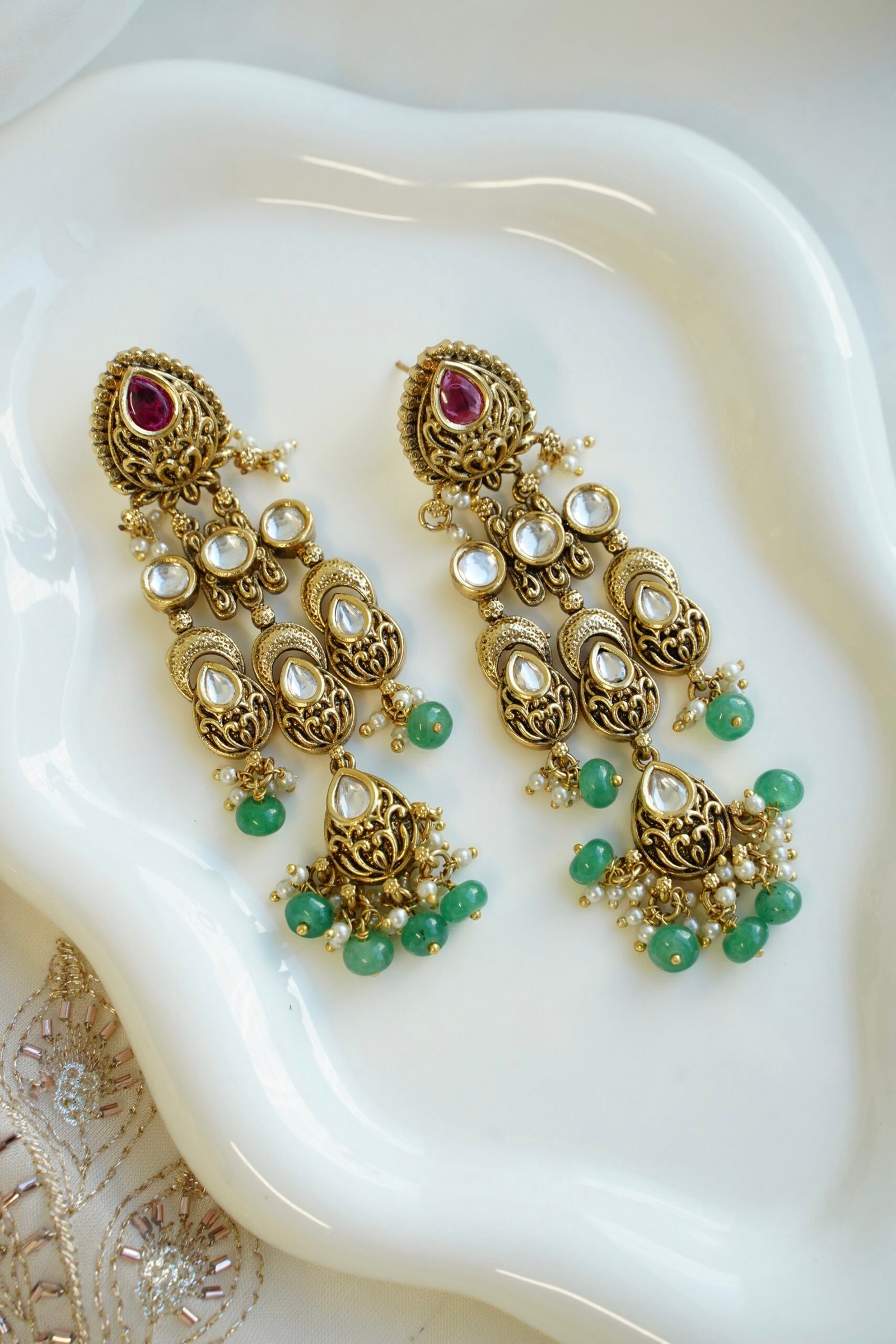 Slim kundan chandelier earrings in pink and green with pearl accents, South Asian festive jewelry