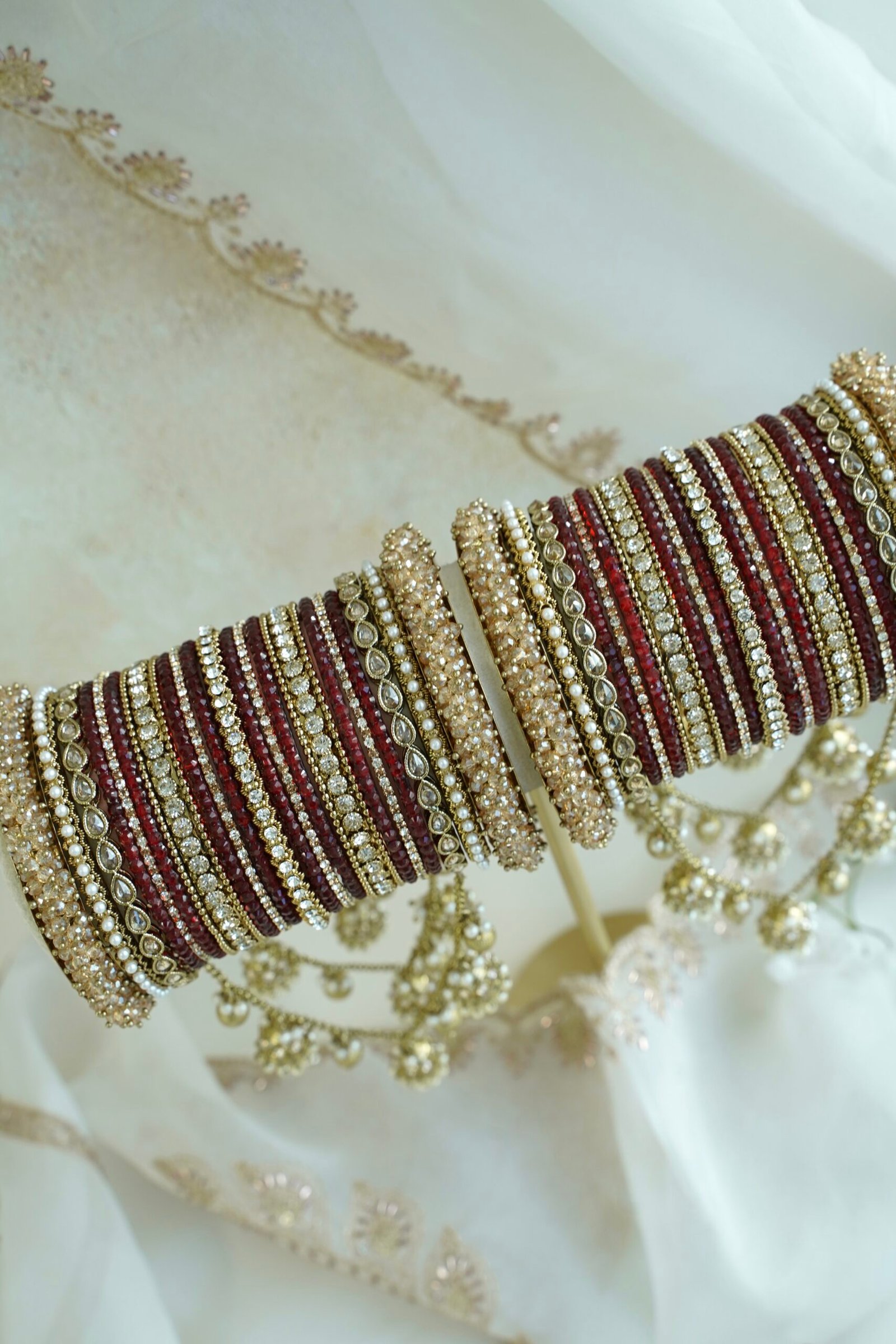 Maroon and antique gold connected bridal bangle set with hanging jhumka charms