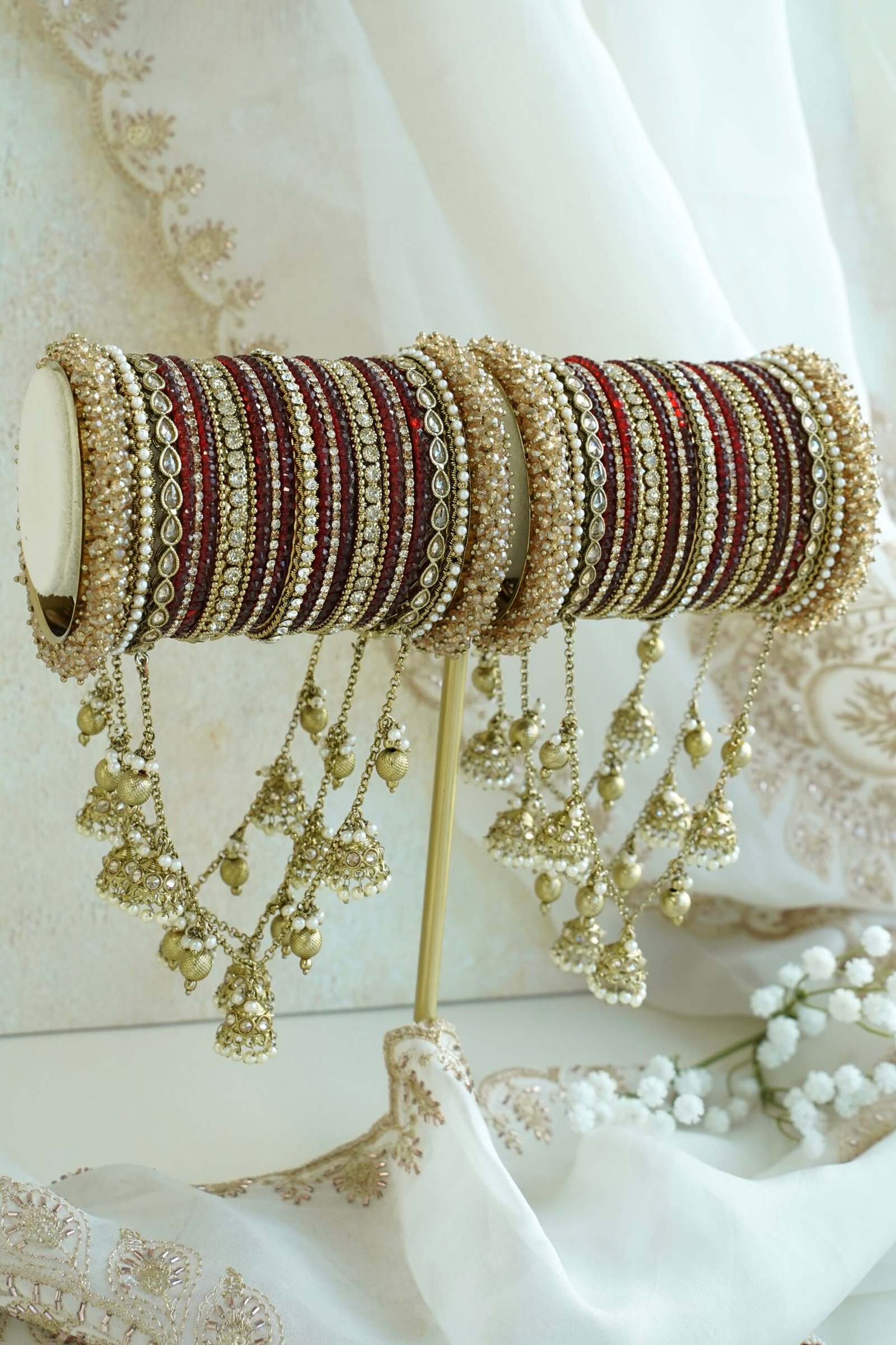 Maroon and antique gold connected bridal bangle set with hanging jhumka charms