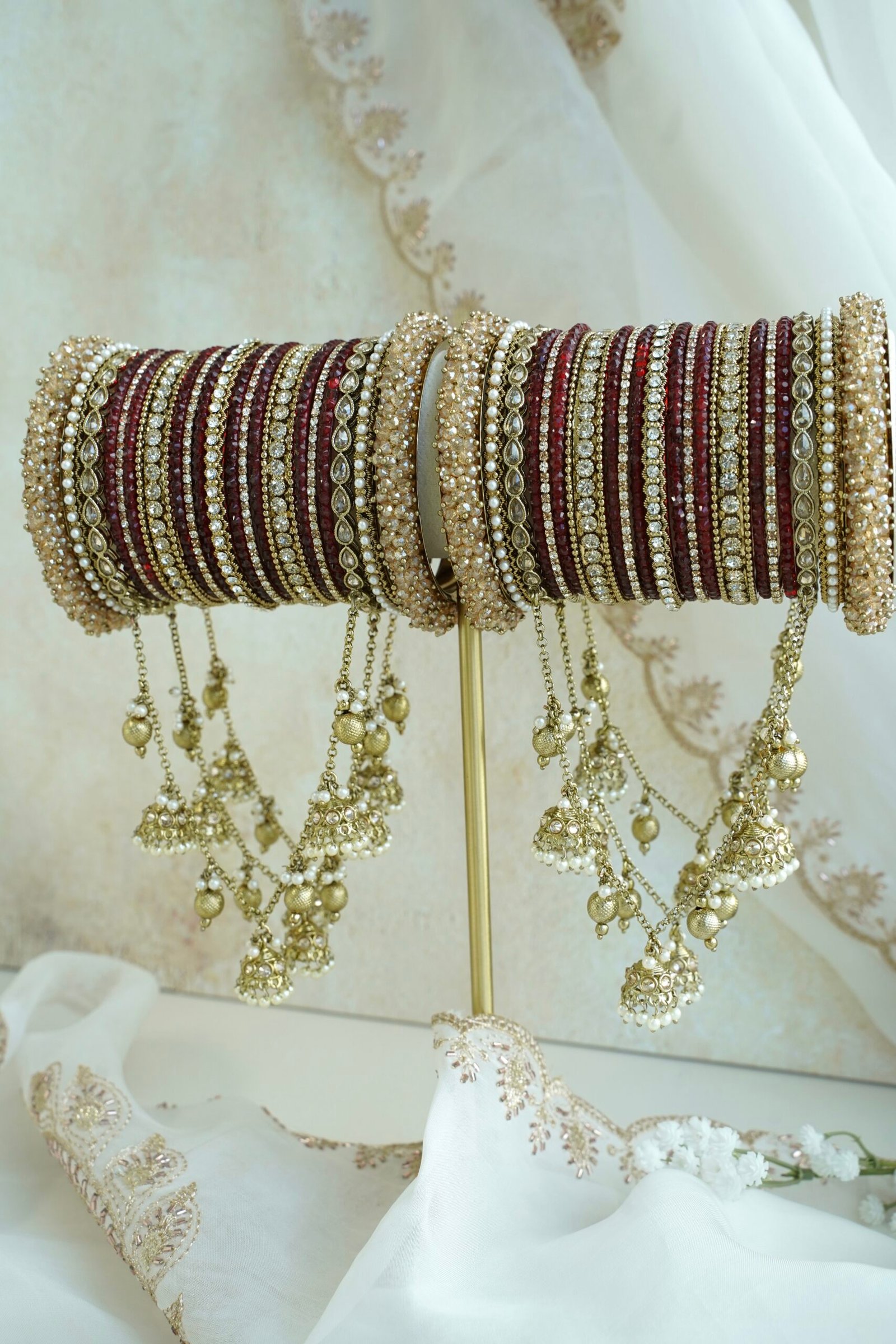 Maroon and antique gold connected bridal bangle set with hanging jhumka charms