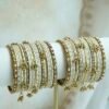 Soft ivory and gold ghungroo bangle set with pearl and stone accents, South Asian festive jewelry
