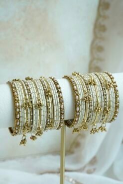 Soft ivory and gold ghungroo bangle set with pearl and stone accents, South Asian festive jewelry
