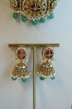 Aaliyah choker set in maroon and green with multi-strand pearl beaded band, antique gold centerpiece, mint green bead drops, jhumka earrings and tikka displayed on a bust