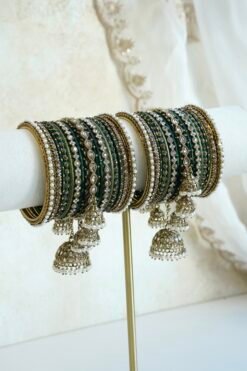Emerald green jhumka bangle set with thread-wrapped green bangles, stone bangles, pearl-style edge bangles, and jhumka charms on a display stand