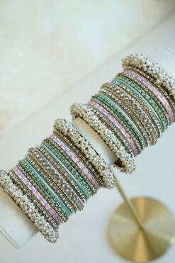 Meenal pastel bangle set with mint and lilac pink bangles, stone-lined bands and pearl-style bead edges stacked on a display stand