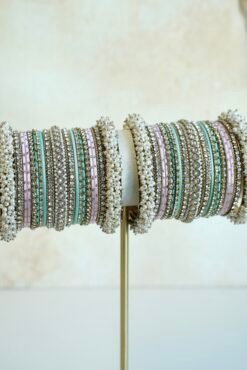 Meenal pastel bangle set with mint and lilac pink bangles, stone-lined bands and pearl-style bead edges stacked on a display stand