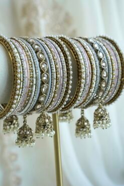 Pastel blush pink and dove gray stacked bangle set with beaded edges, champagne teardrop stones, and hanging jhumka charms
