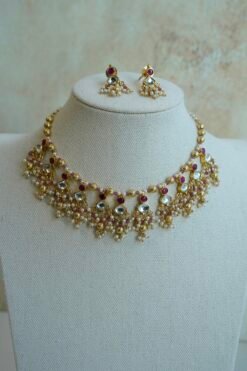 Pink pachi pearl drop necklace set with pink and clear stones, pearl-style bead clusters and matching earrings displayed on a bust